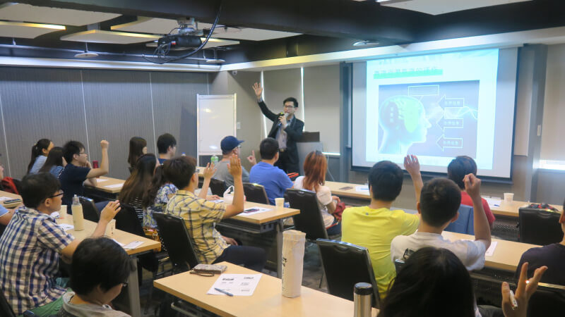 這是一張照片 陳唐催眠師在課堂中講解催眠技術，學員積極參與互動，學習潛意識控制技巧。